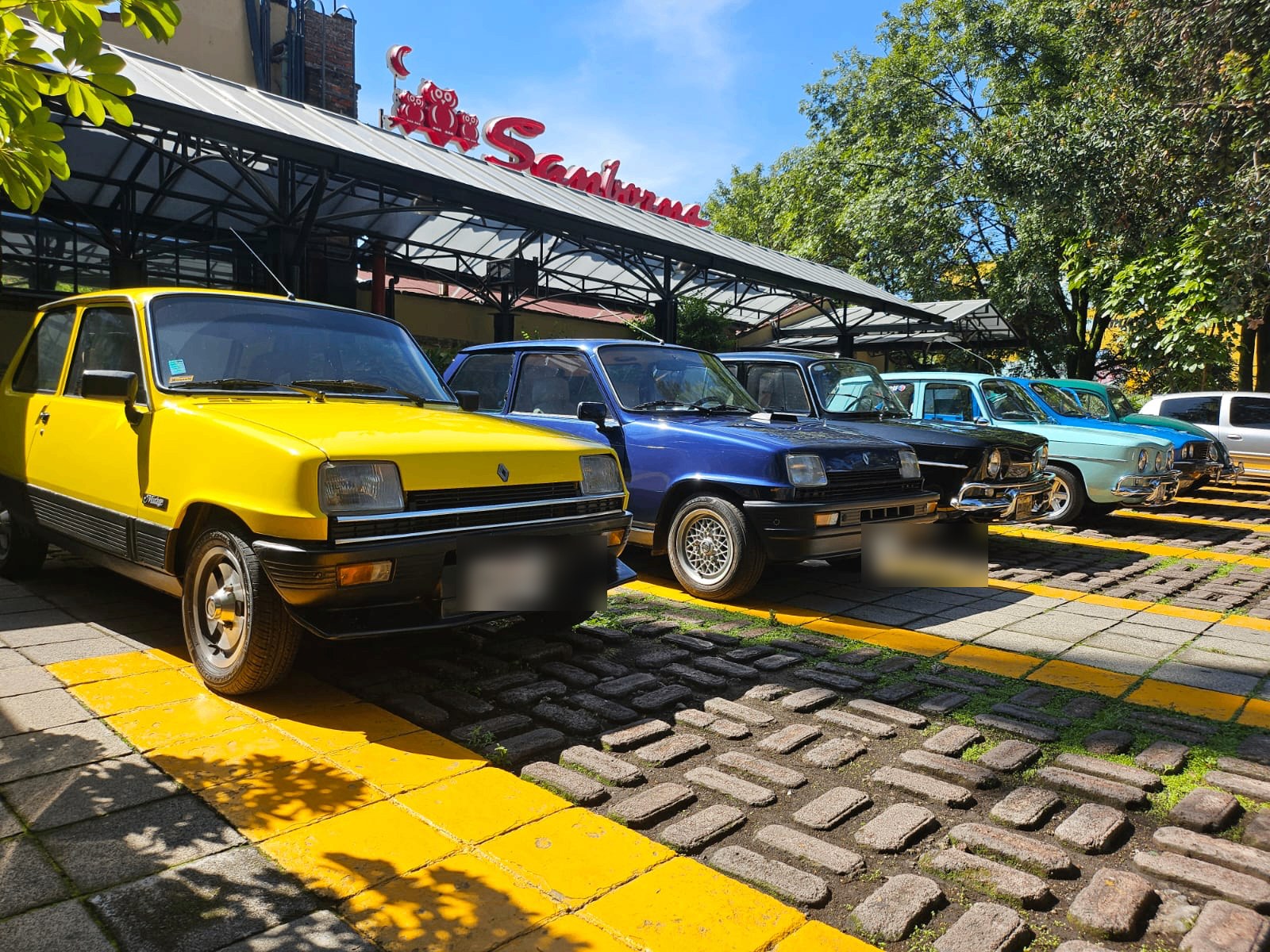 Renault 5 Mirage amarillo, Renault 5 azul, Renault 8 negro y otros clásicos del club durante el desayuno del 12 de julio de 2026 en CDMX, con matrículas difuminadas