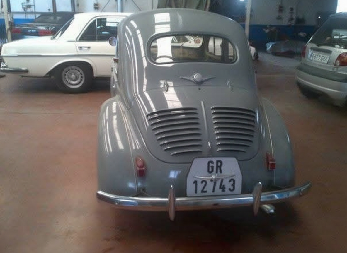 Renault 4CV gris visto de atrás en un taller en Europa antes de salir hacia México