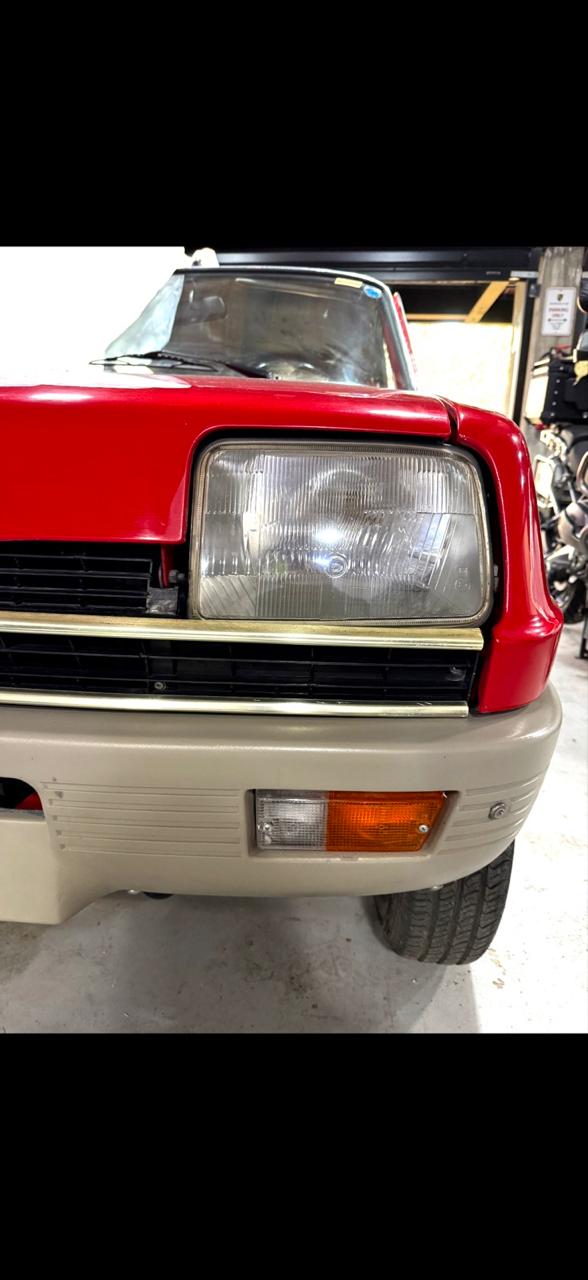 Detalle del frente y faro de un Renault 5 rojo