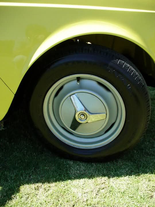 Detalle del rin y tapón original de un Renault 4L amarillo