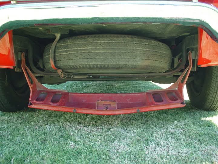 Llanta de refacción original alojada en el frente del Renault 10 rojo